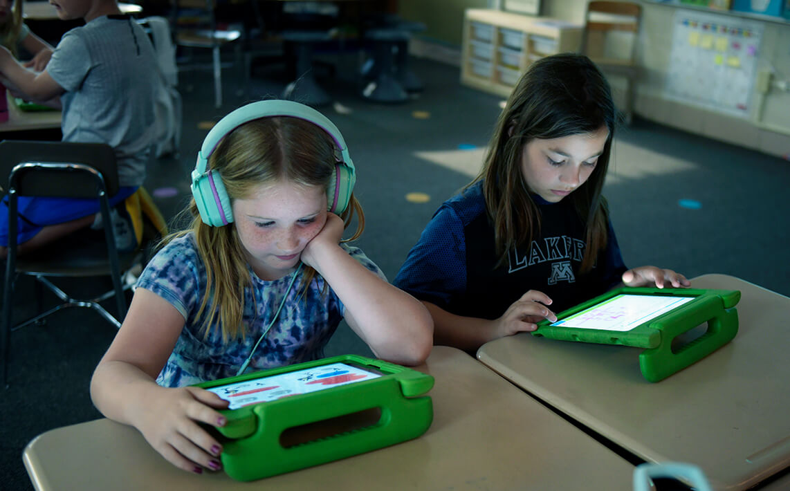 Elementary students learning on devices
