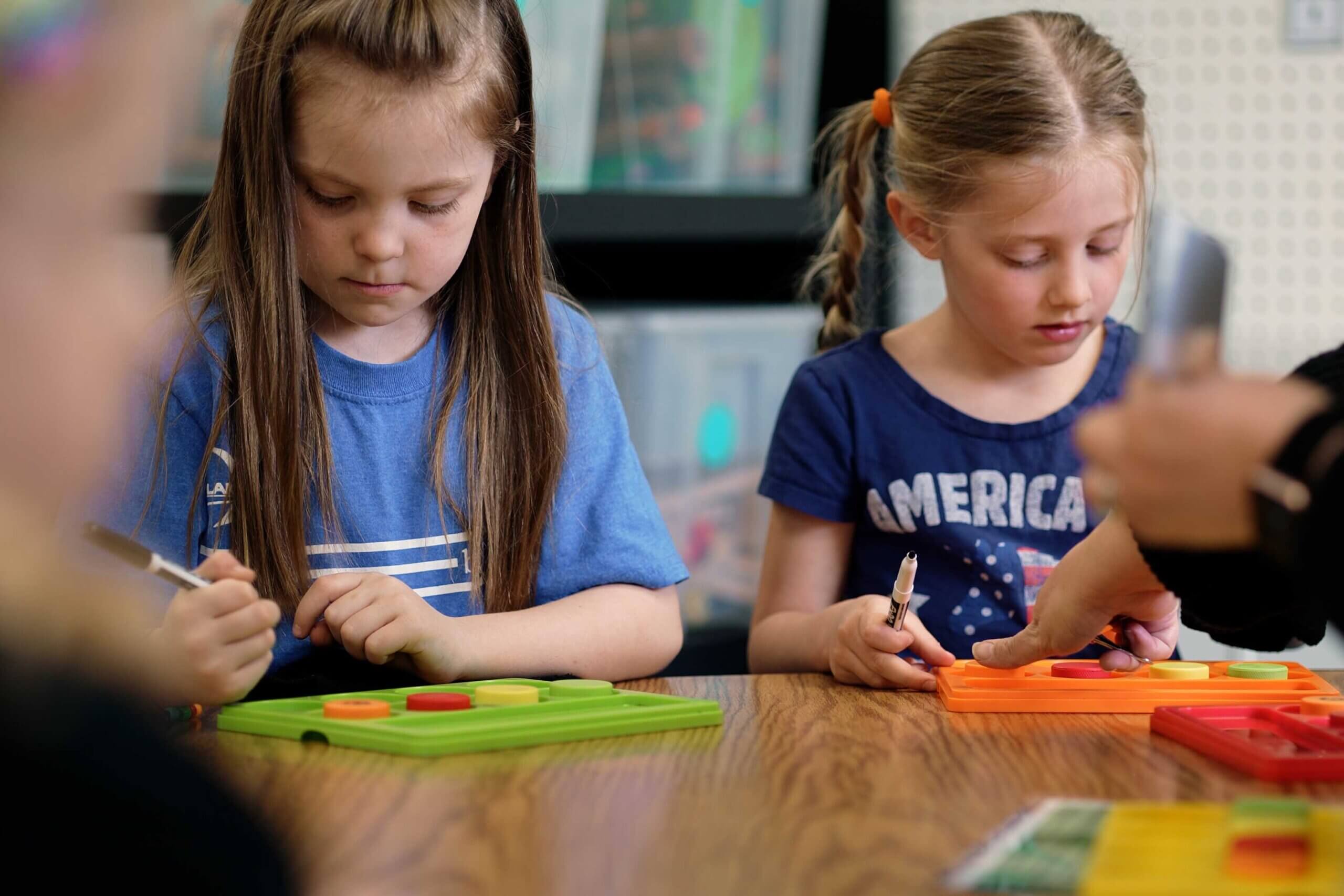 Two elementary school girls learning in a classroom