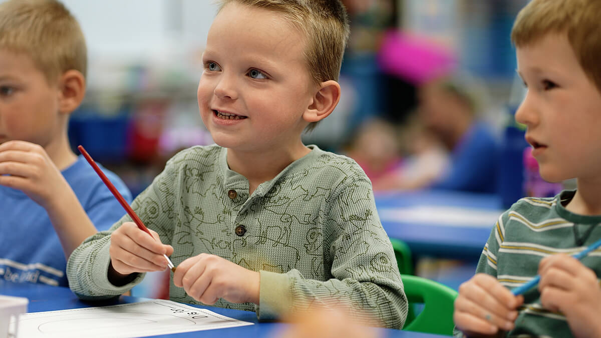 Three preschool boys painting