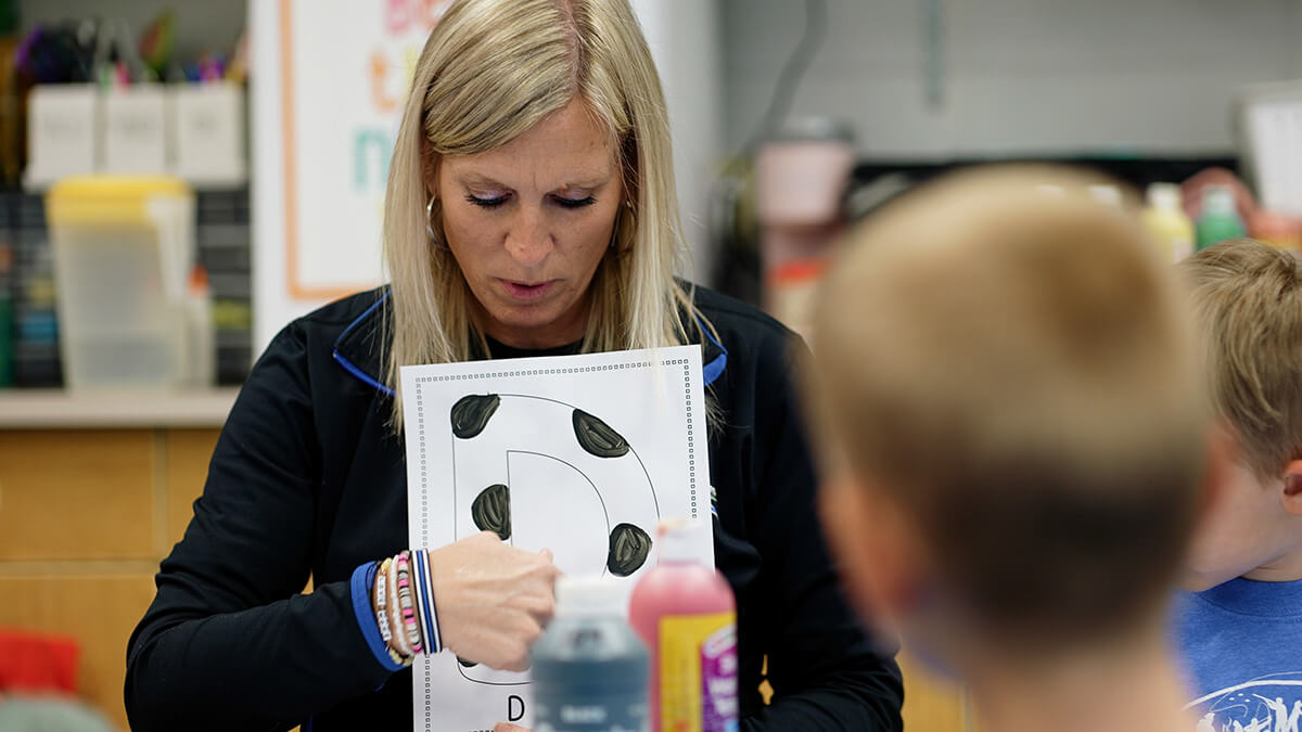 Preschool teacher presenting the letter D to students