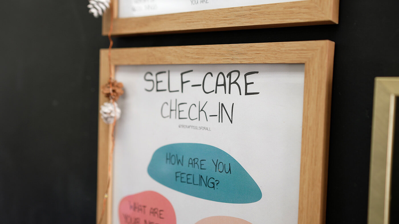 Self-care check-in poster on the wall