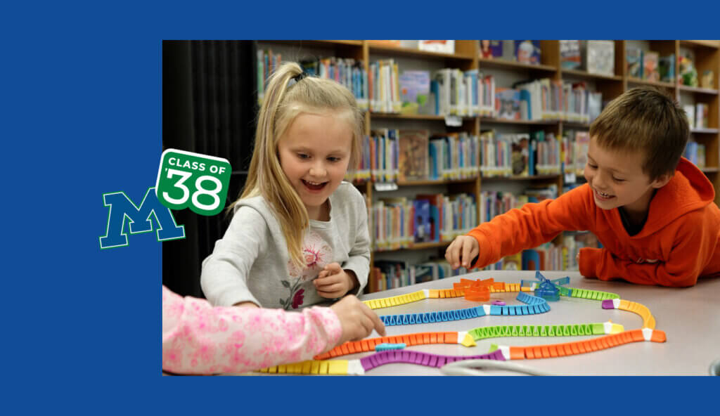 Two kindergartners playing in a classroom